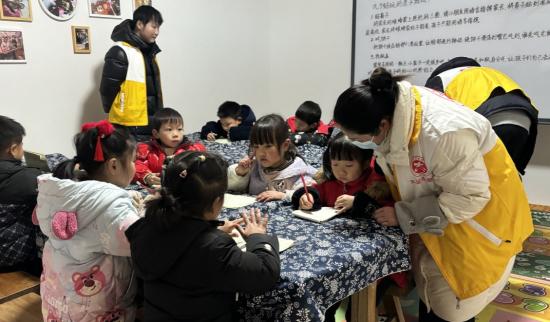 志愿者輔導(dǎo)學(xué)生做作業(yè)。 （回龍鎮(zhèn)供圖）