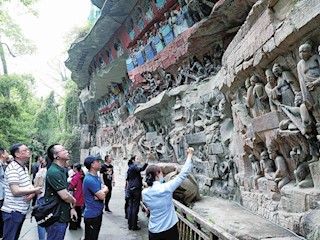 游客在大足石刻寶頂山景區(qū)參觀